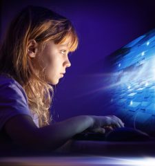 Little,Blond,Girl,Working,On,Computer,In,Dark,Room,At